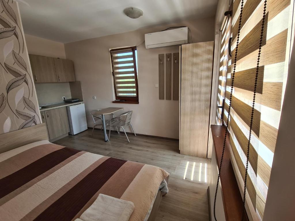 克拉佩茨House Varna-1的一间卧室配有一张床铺和一张桌子,还设有一间厨房
