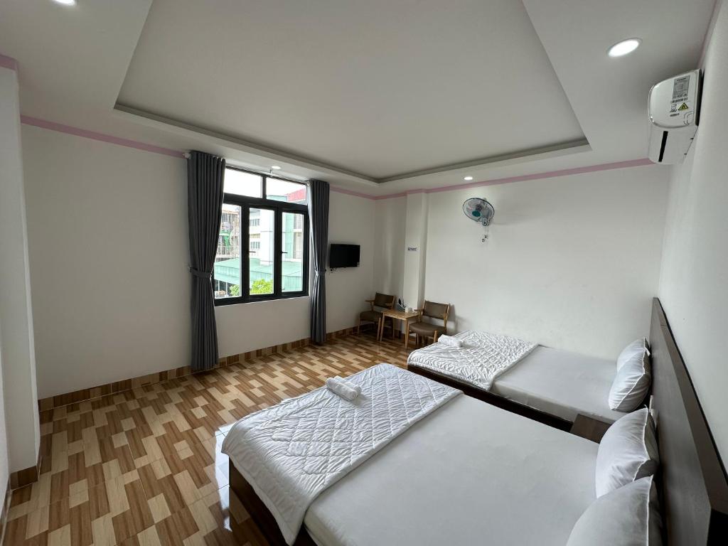 顺安Hotel Trang Huy的客房设有两张床和窗户。