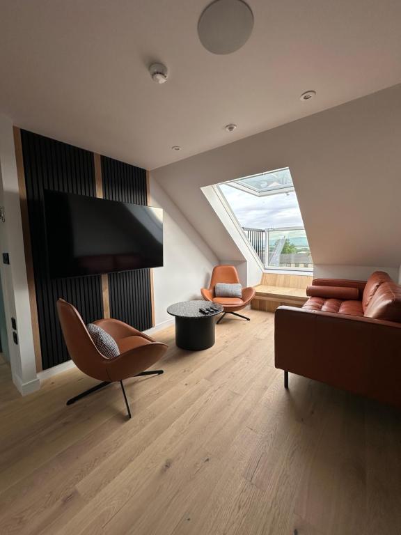 Laurieston Penthouse的客厅配有沙发、椅子和电视