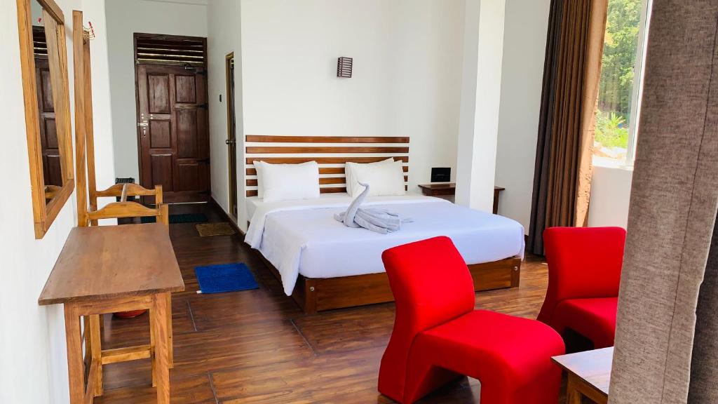 哈普特莱Nilowin Glenanore Guesthouse的一间卧室配有一张床和两张红色椅子