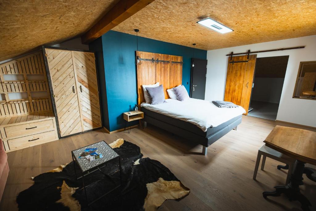 克莱恩 蒙塔纳B&B La Forge de Diogne的一间卧室设有一张床、蓝色的墙壁和一张桌子