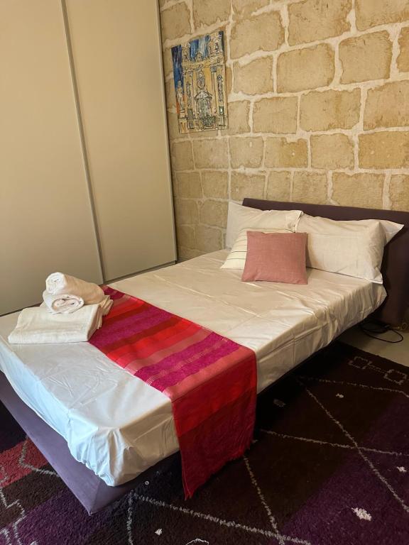 GħargħurLuxury room in Gharghur的砖墙旁边的一个房间里的一个床位