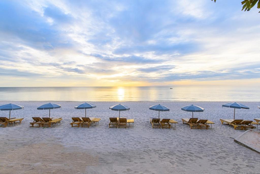 华欣瓦兰达洛奇酒店的海滩上的一组椅子和遮阳伞