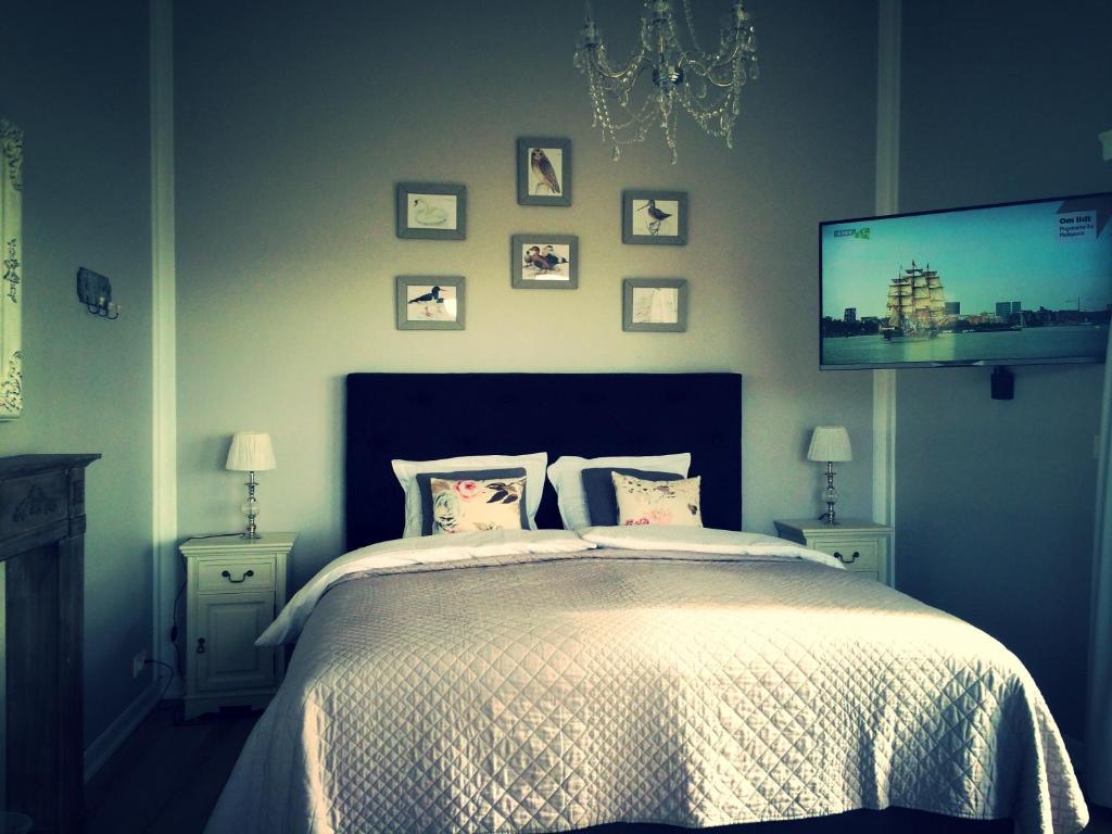 华姆斯唐吉慕课高级度假屋的一间卧室配有一张床和一台平面电视
