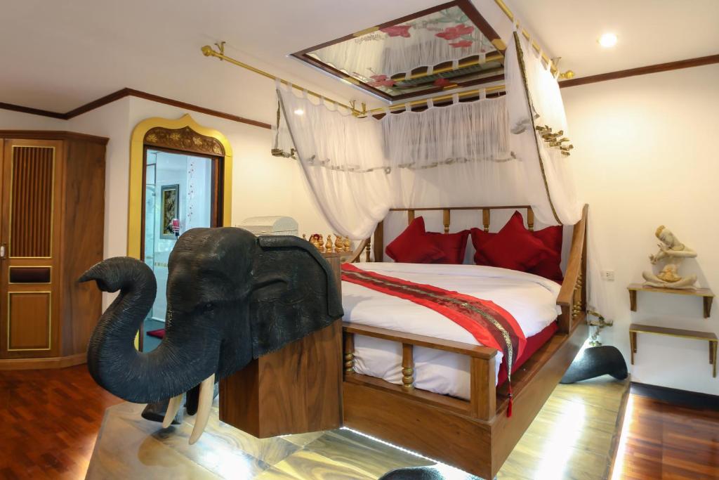 清迈Olivier Boutique的卧室配有一张床上大象雕像