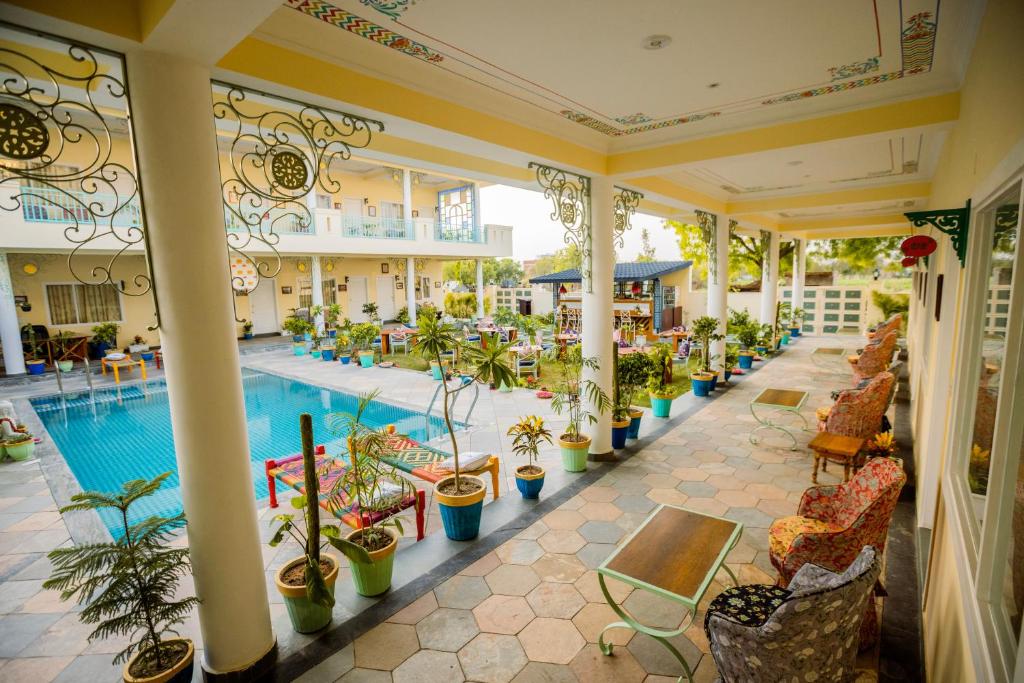 阿格拉Dá Bungalow - A Vacation Abode的室内大堂设有游泳池和植物