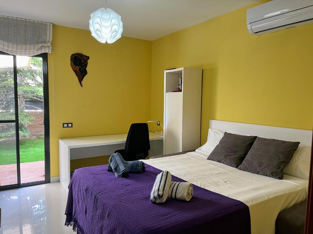 卡涅利亚斯Washingtonia Villa near Sitges的一间卧室配有一张带紫色毯子的床
