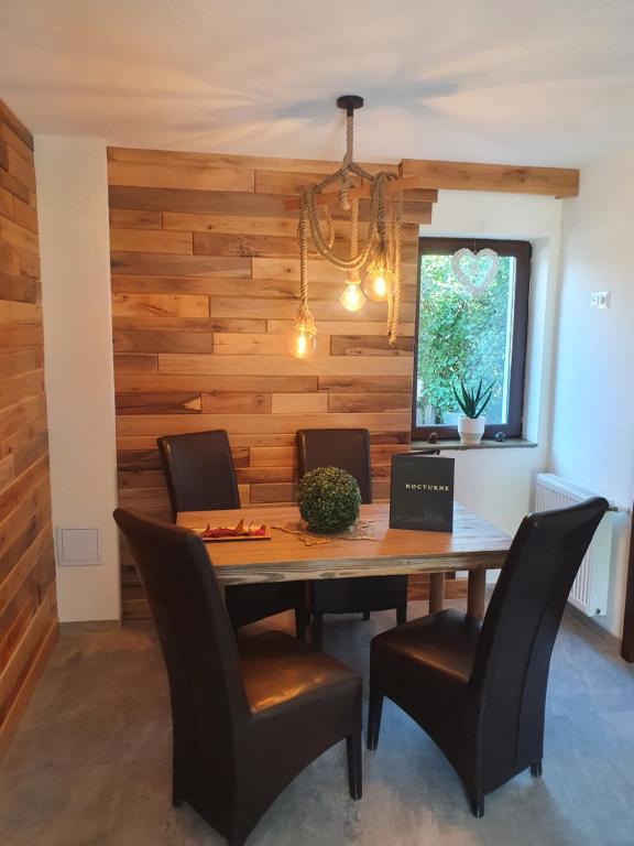 科瓦斯纳Pensiunea transilvania的用餐室设有木墙,配有桌椅
