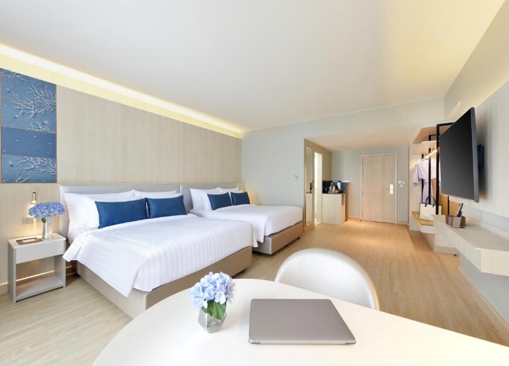 曼谷水门中心点酒店的一间酒店客房,设有两张床和电视