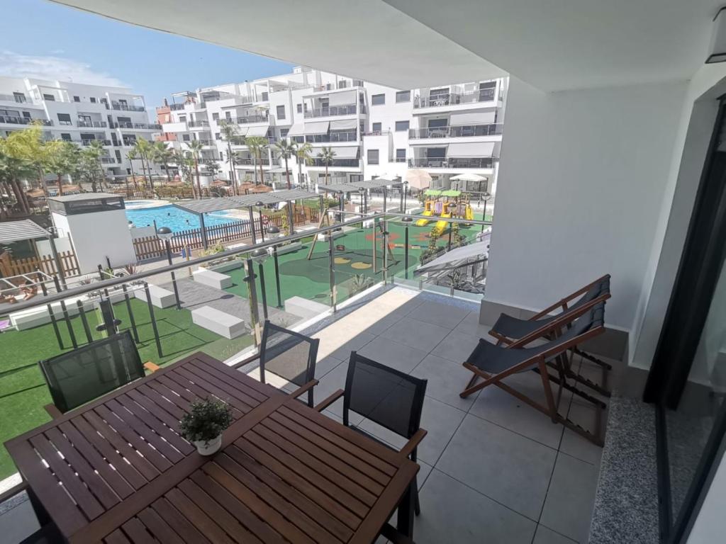 莫特里尔Playa & Golf Deluxe en Playa Granada的阳台配有桌子,享有游泳池的景色