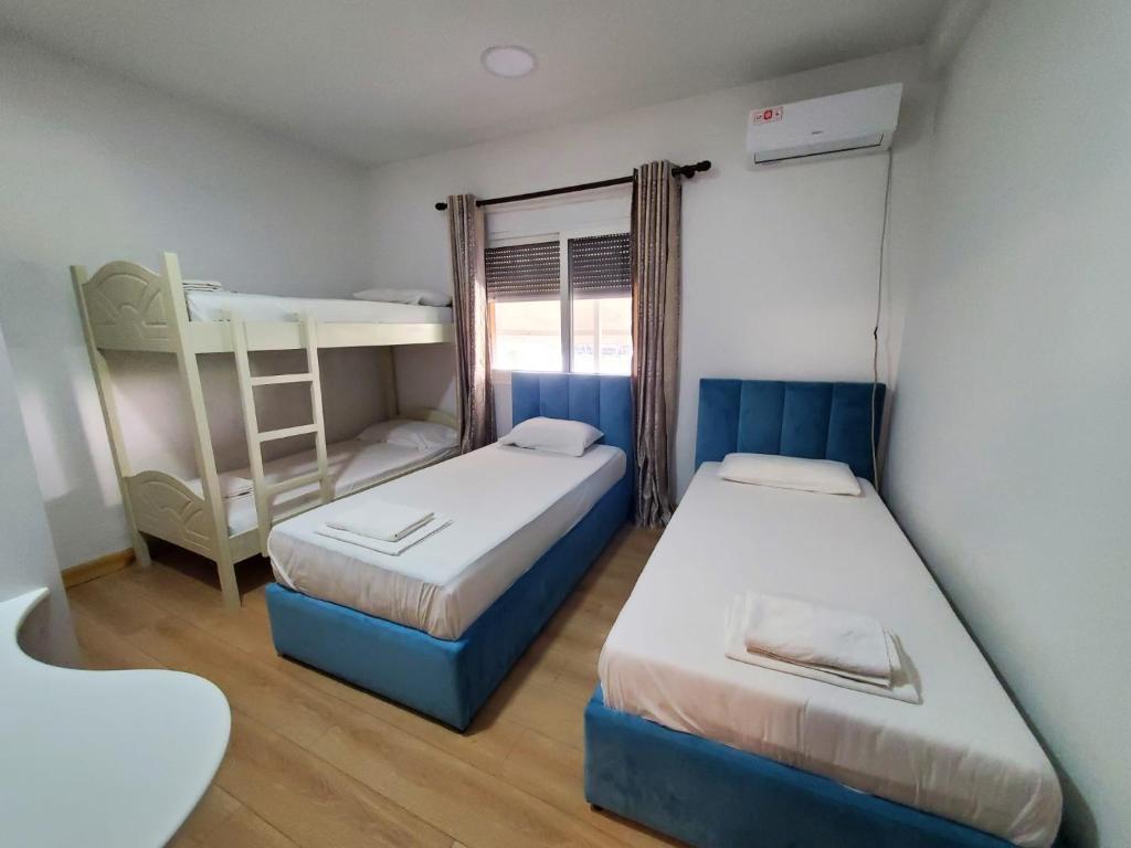 都拉斯Top view hostel的一间卧室配有两张床和一张双层床。