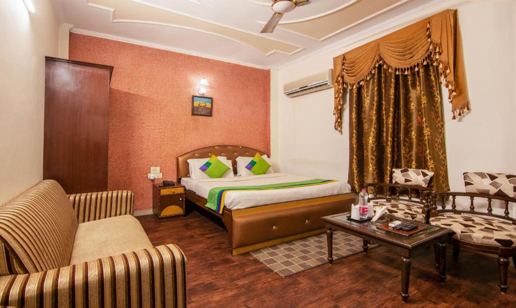 新德里Treebo Trend Paras International的酒店客房,配有床和沙发