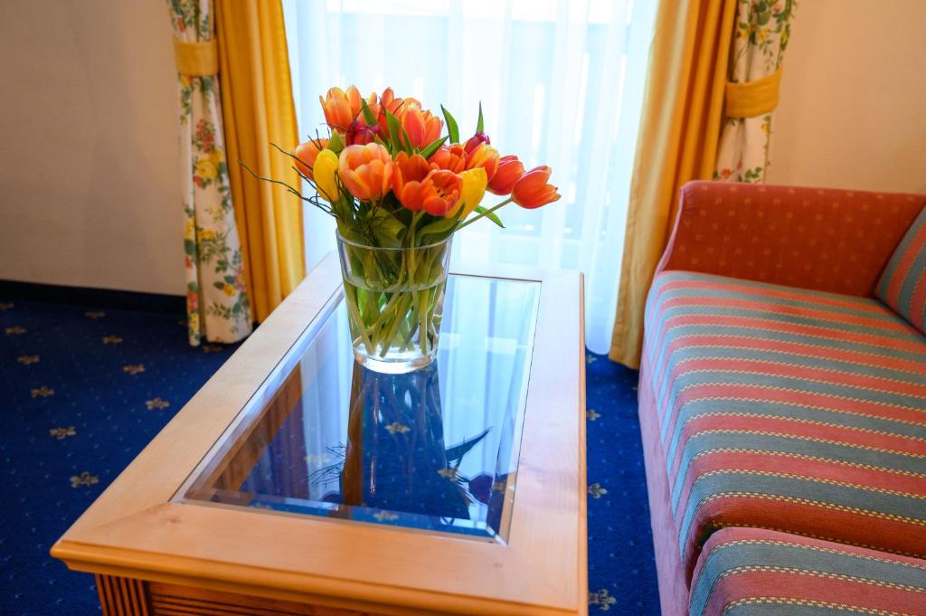 翁特陶埃恩Hotel Hammerwirt - Forellenhof的沙发旁边的桌子上花瓶