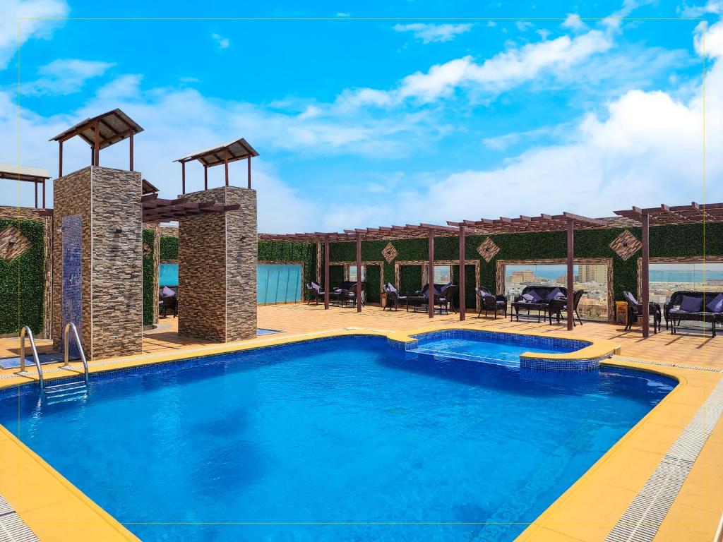 阿可贺巴هوليداي الخليج الخبر Holiday Al Khaleej Hotel的一个带桌椅的度假村游泳池