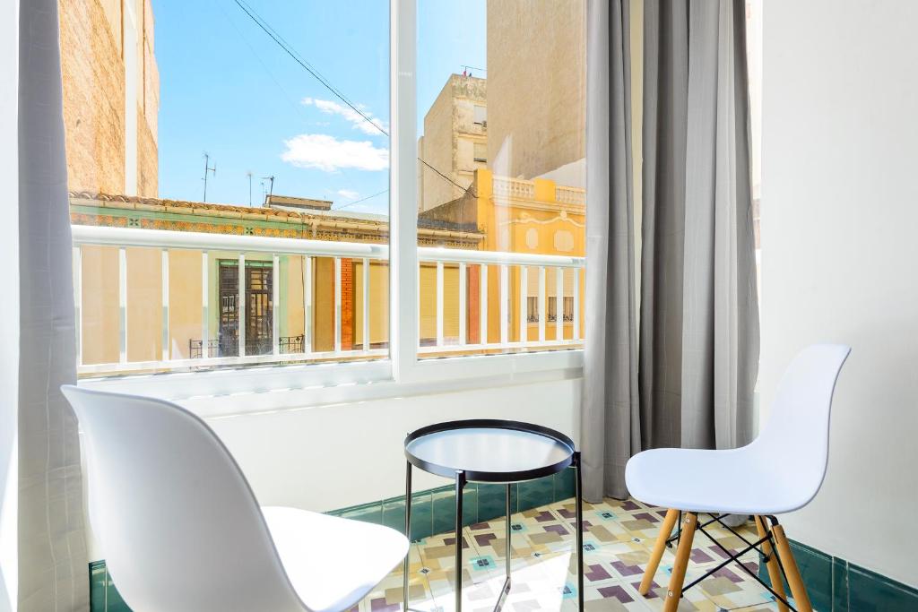 卡斯特利翁-德拉普拉纳Bieti Castellon的阳台配有两把白色椅子和窗户。