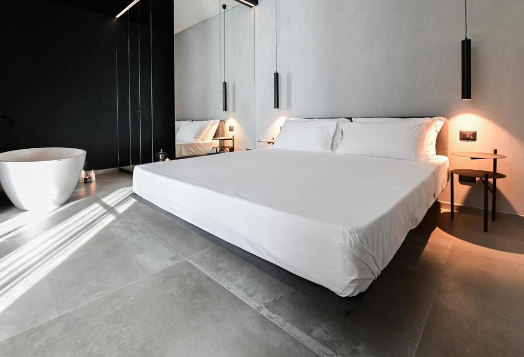 西维尔诺瓦·马尔凯LE MARIN contemporary apartments的卧室配有一张白色大床和浴缸