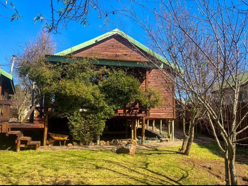 德尔斯特鲁姆Cinnamon & Sage Country Cabins的大型小木屋,设有绿色屋顶