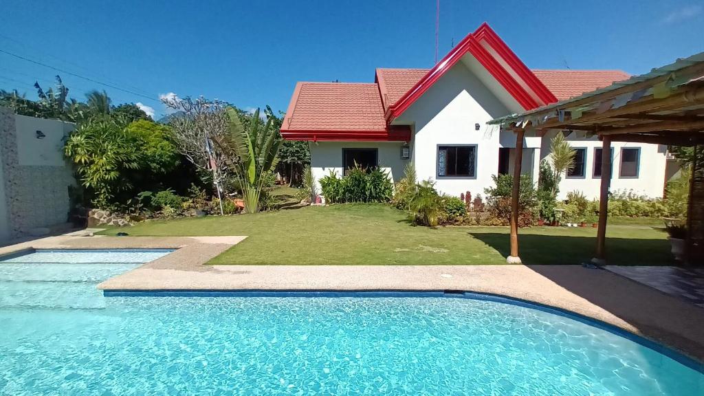 杜马格特Villa Shangri-La的房屋前有游泳池的房子