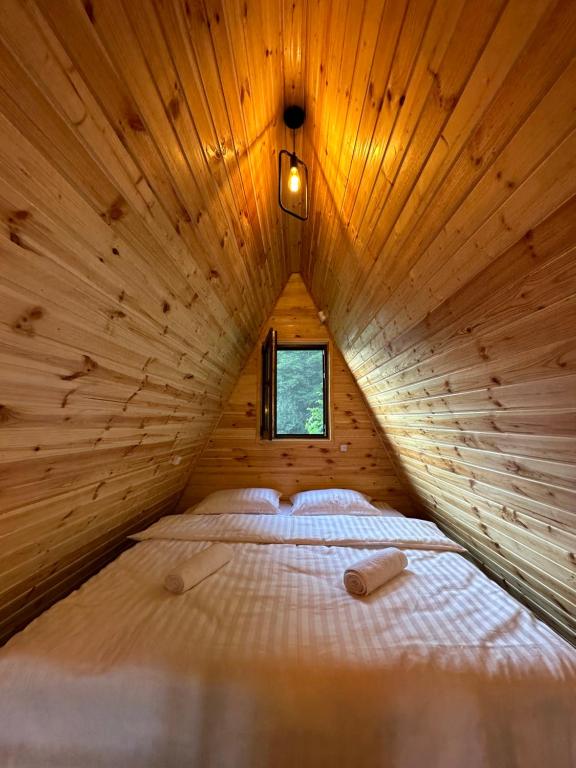 GhebiGlacier Shoda的木制客房内的一张大床,设有窗户