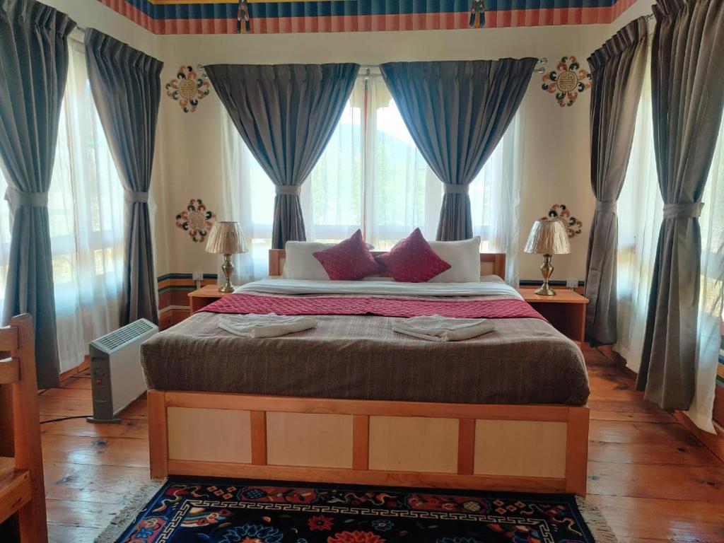 帕罗Nirvana Lodge的一间卧室配有一张带蓝色窗帘的大床
