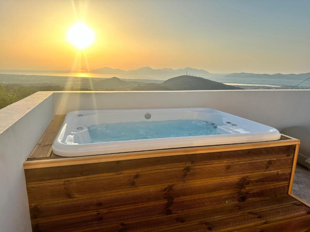 Lagoúdi ZíaLΟFT by Casa di Somnia的阳台上的按摩浴缸享有日落美景