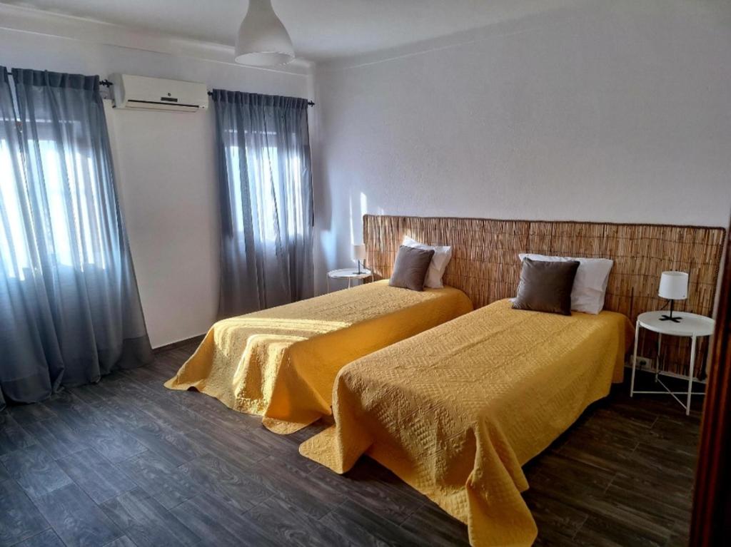 ErvedalMorgado Guest House的酒店客房带两张带黄床单的床