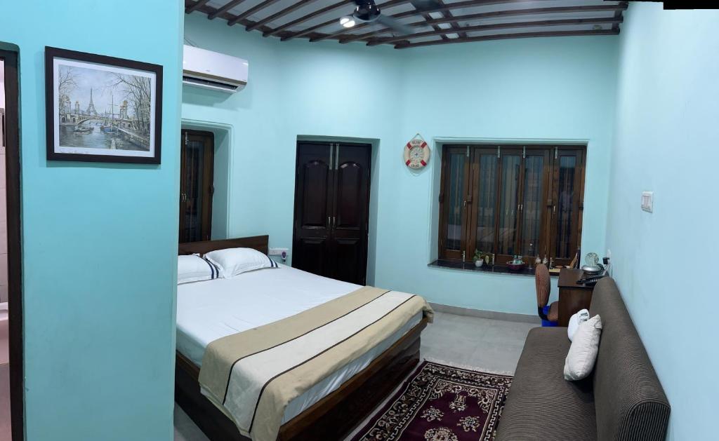 加尔各答Teakwood Suite - Nokha House的一间卧室配有一张床和一张沙发