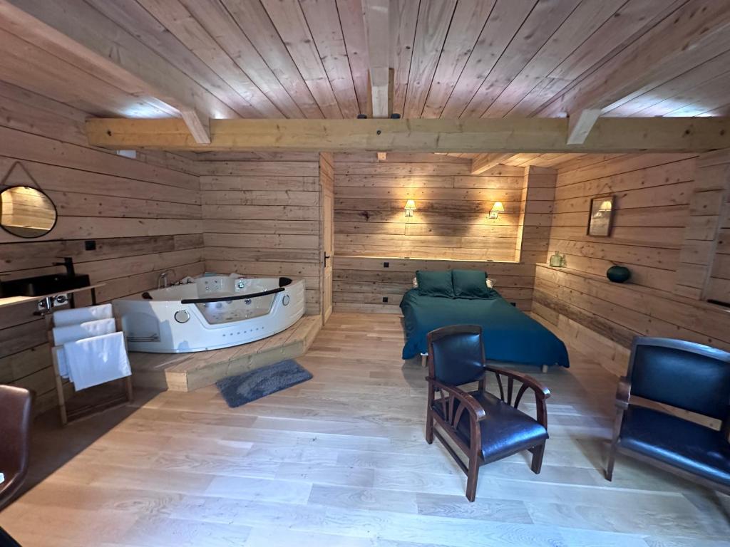 莱索里涅尔Le Chalet的一间带床和浴缸的桑拿浴室