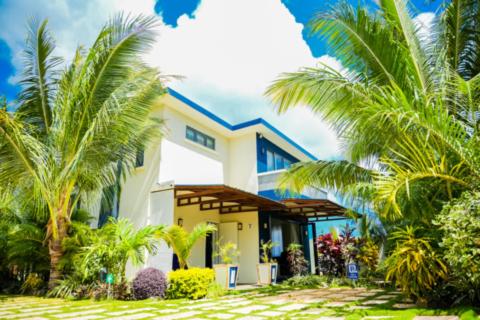 格兰贝伊Preety Blue Residence villas的前面有棕榈树的房子