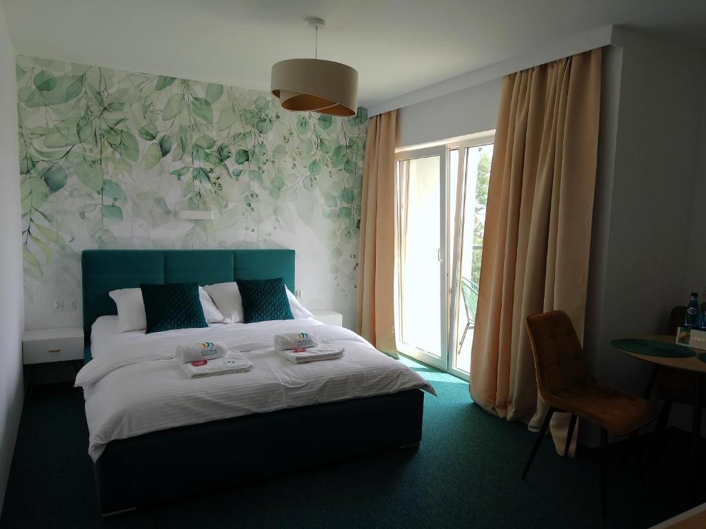 亚斯塔尔尼亚Apartamenty Mistral的一间卧室配有一张带绿色床头板的床和窗户