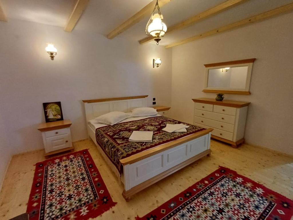 Grădiştea de MunteCasuta din Valea Regilor的一间卧室配有一张床和两块地毯