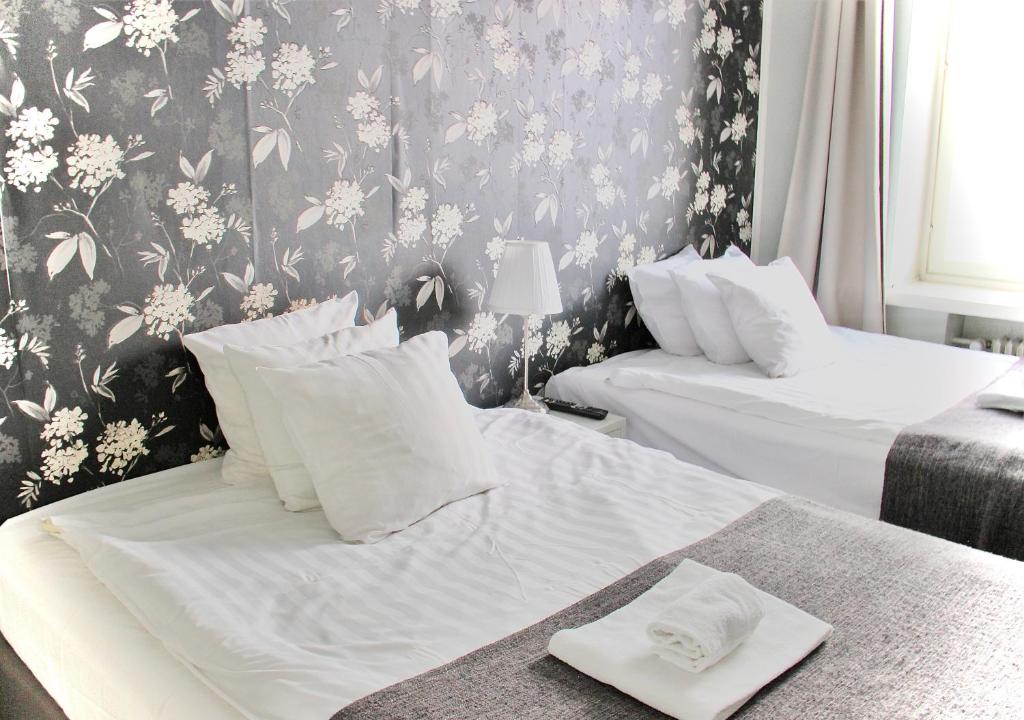 赫尔辛基Orchidea Kamppi的一间卧室设有两张床和花卉壁纸