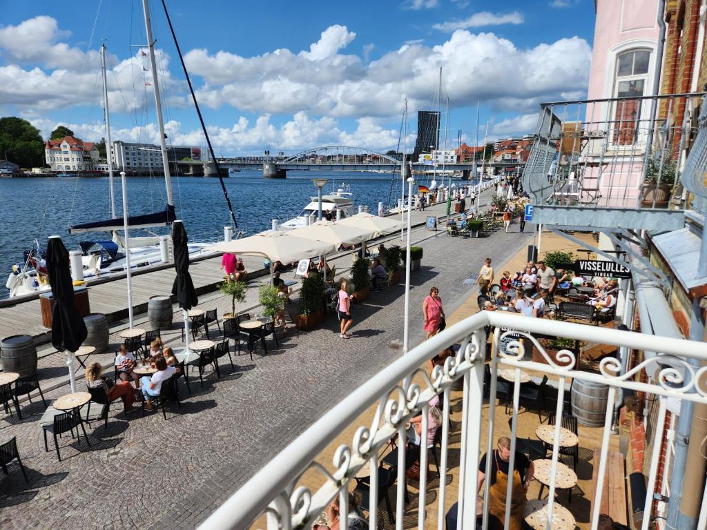 森讷堡Harbour View的阳台,人们坐在水面的桌子上