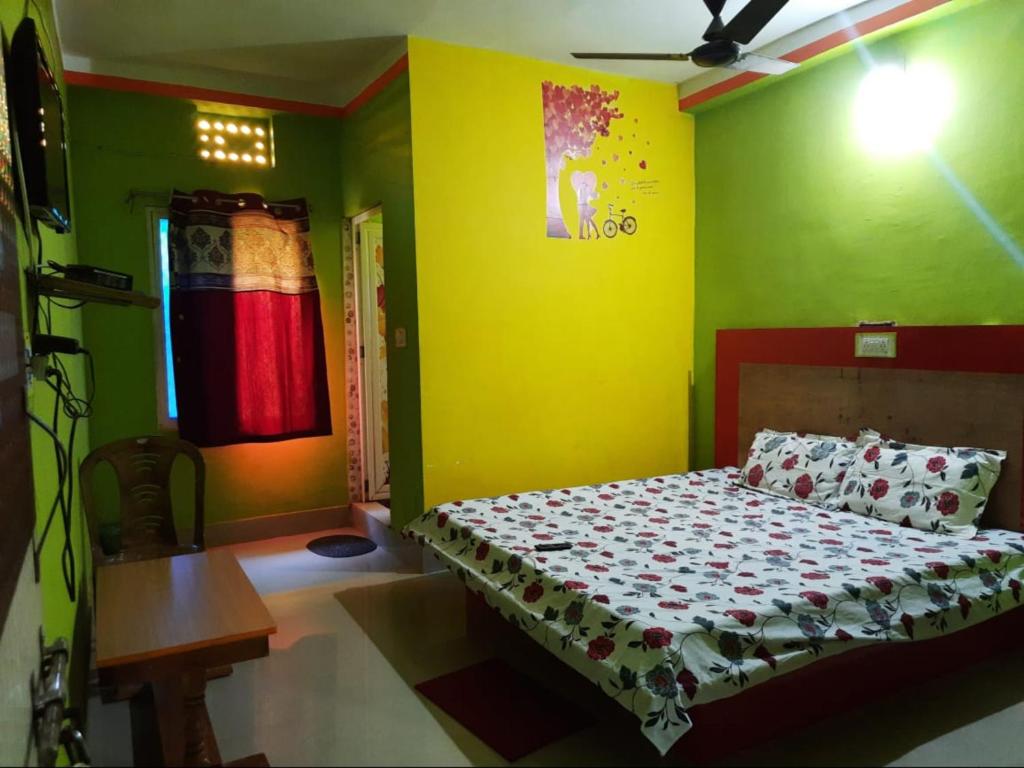 科纳卡Goroomgo Sun Plaza Lodge konark的一间卧室设有一张床和黄色的墙壁