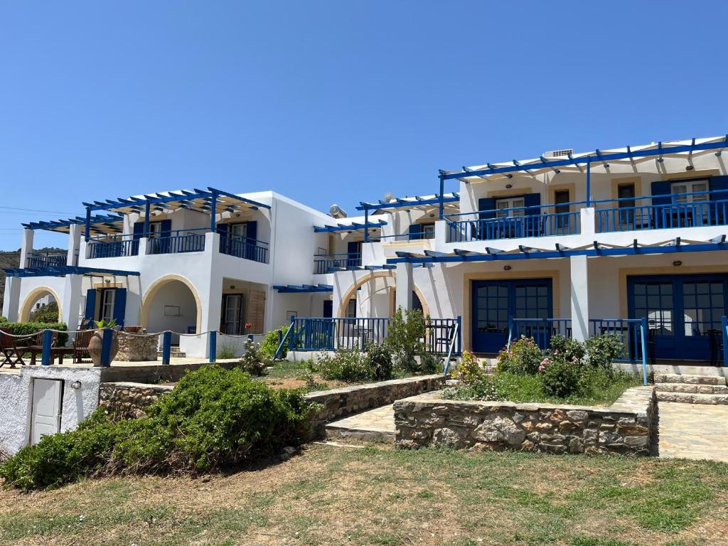 Platia AmmosΞΕΝΟΔΟΧΕΙΟ ΑΚΡΩΤΗΡΙ的白色的大建筑,设有蓝色的阳台和楼梯