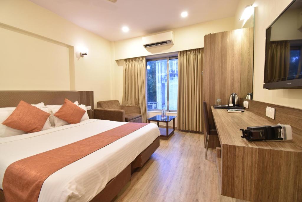 孟买Hotel Atlantic的配有一张床和一张书桌的酒店客房