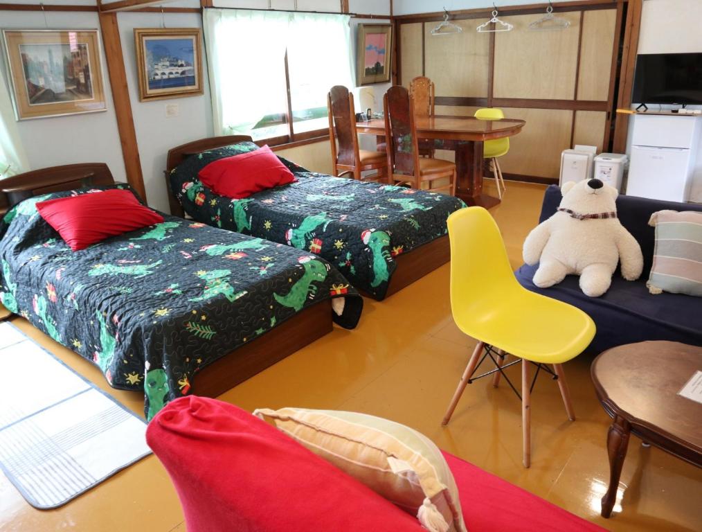 立山町Pension Alba - Vacation STAY 70965v的客厅配有三张床和一张黄椅