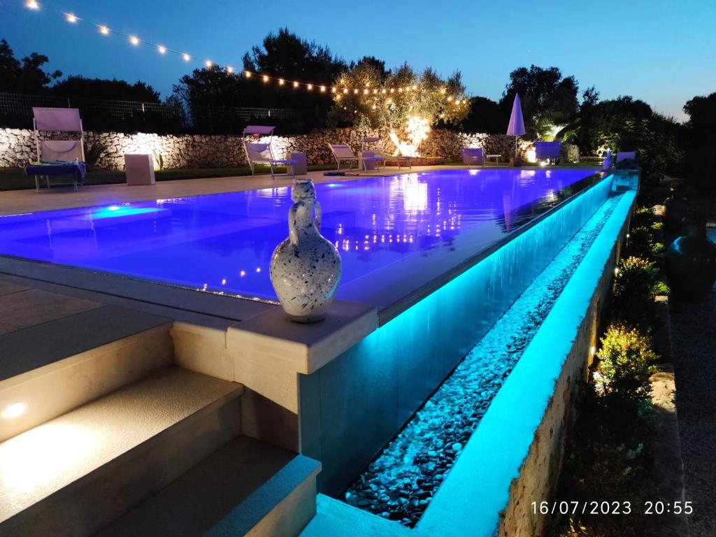 奥斯图尼Bed & Breakfast dei Colli的游泳池在晚上点亮,灯光照亮