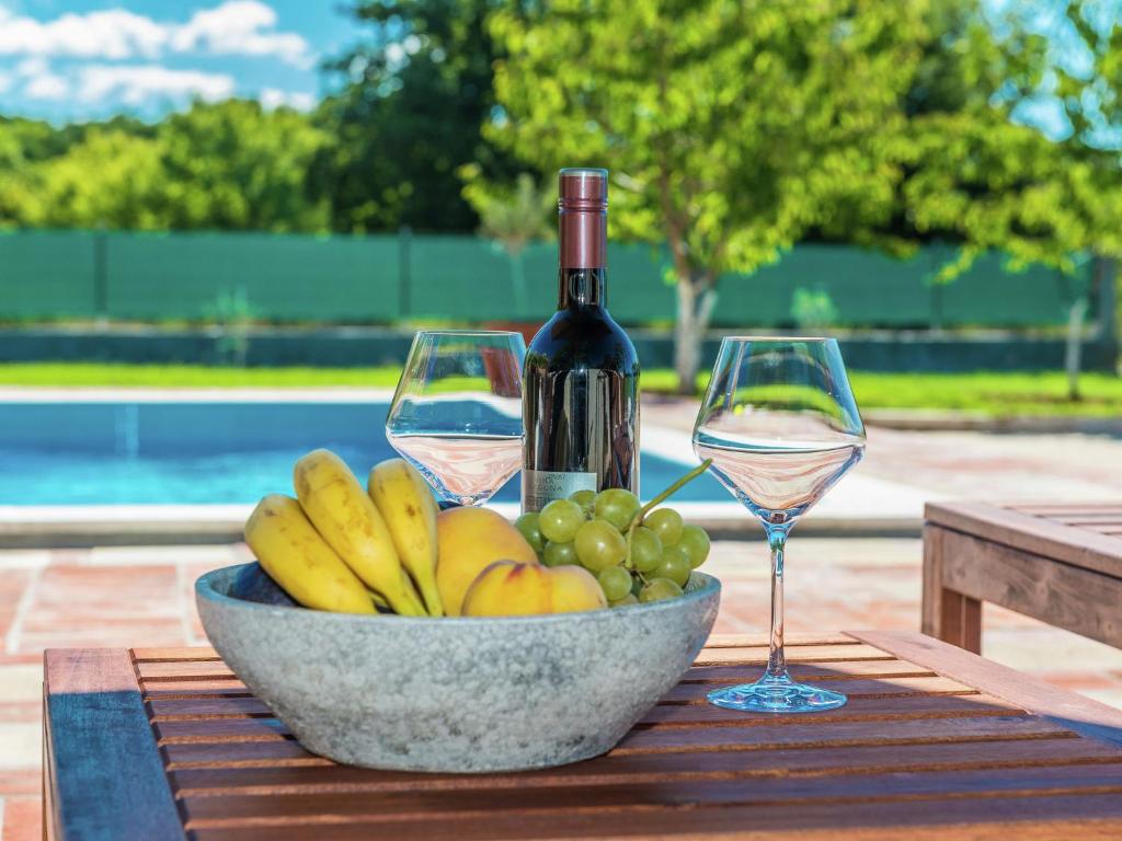Donji ZemunikCharming holiday home with private pool的一瓶葡萄酒和两杯水果