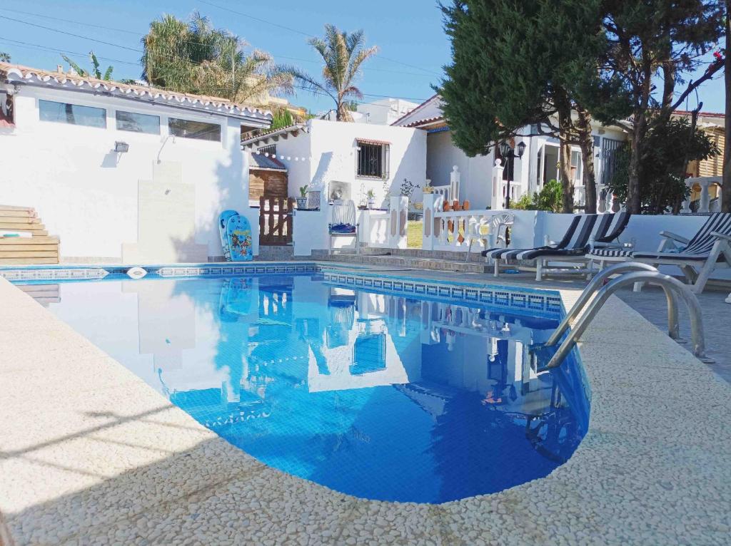EsteponaChalet privado buenas noches的一座拥有蓝色海水和白色建筑的游泳池