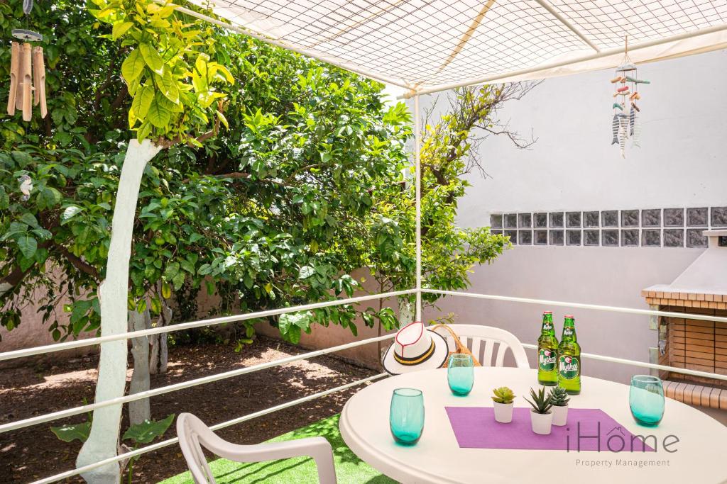 毕达哥利翁I Love Samos - Maisonette at the heart of Pythagorio的庭院配有桌椅和遮阳伞。