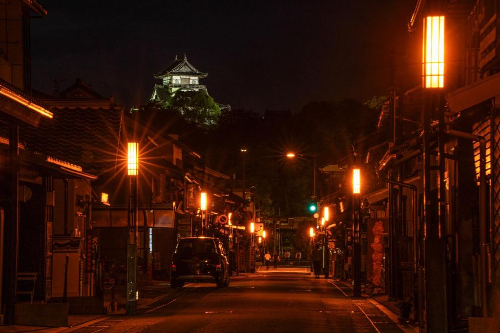 犬山市游月庵的城市街道,在晚上,有一座建筑背景