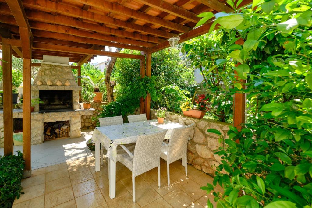木洛希尼Apartman Mirjana 1的庭院配有桌椅和壁炉。