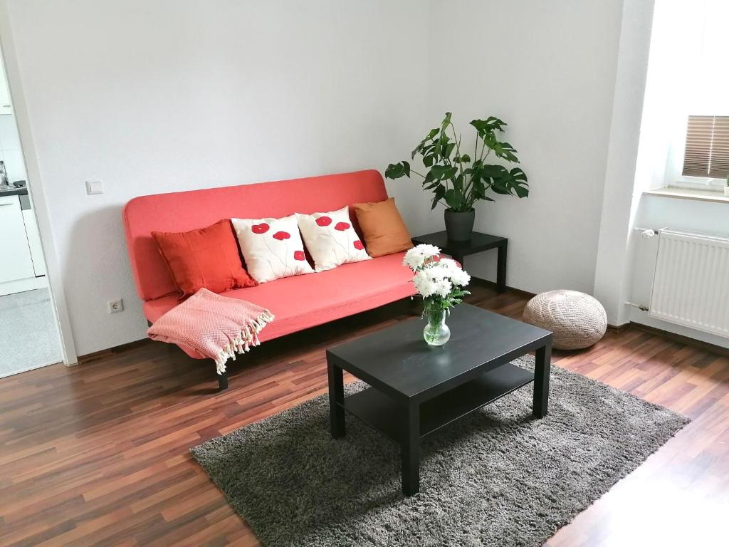 赫恩Wohnung in Herne Zentral mit Küche, Netflix, Disney Plus, DAZN的客厅配有红色的沙发和桌子