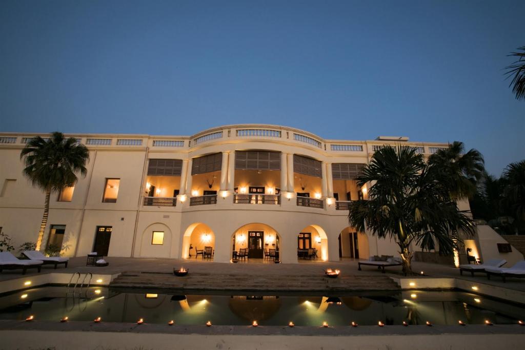 瓦拉纳西纳德萨泰姬陵酒店&度假村的一座大型建筑,前面设有一个游泳池