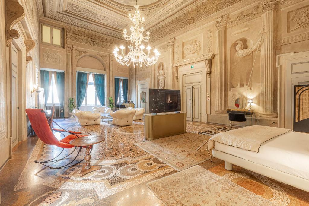 维罗纳Corte Realdi - Palazzo Camozzini的一间带一张床和吊灯的客厅