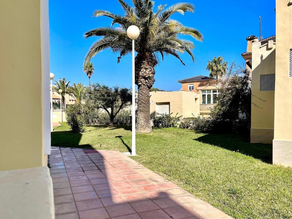 滨海罗克塔斯Beachfront apartment in Roquetas de Mar with communal pool的一条有人行道的院子内的棕榈树