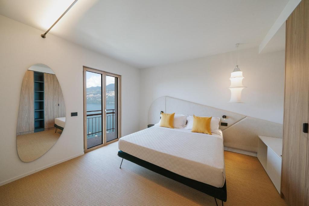 布雷佐内加尔达VIEW Garda Lake的白色卧室设有一张大床和镜子