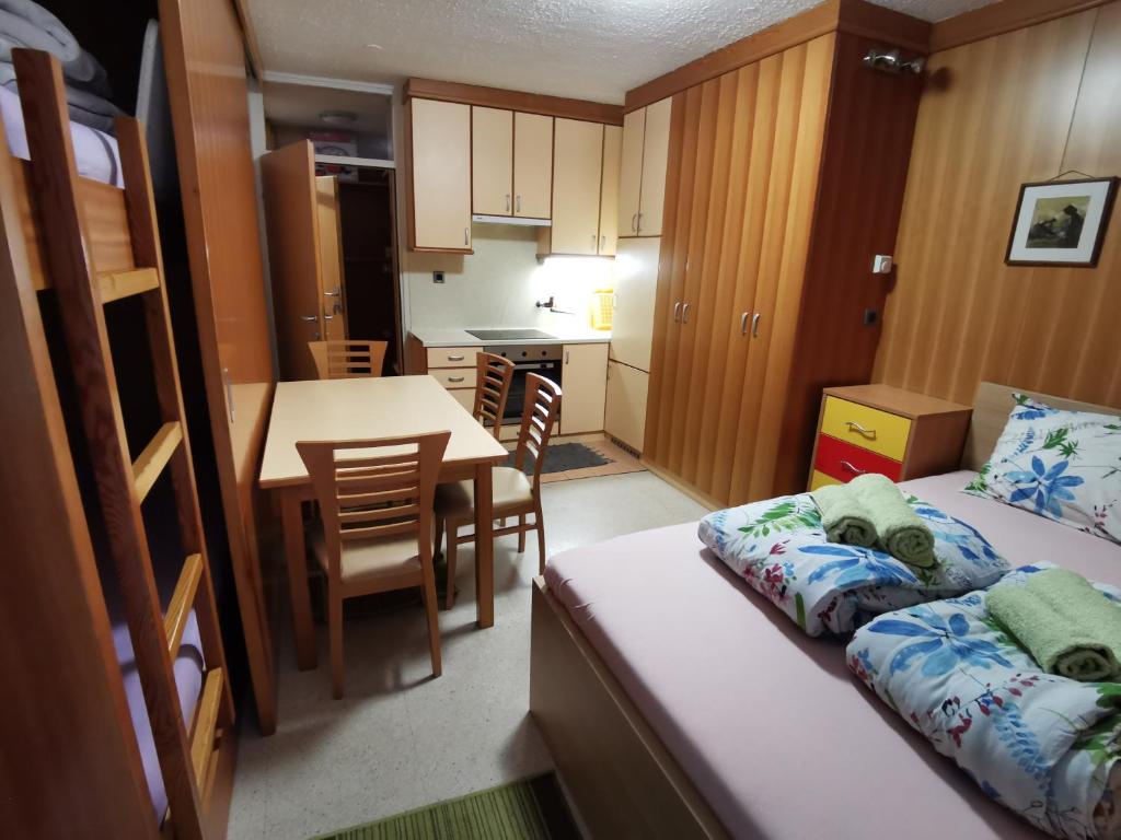 兹雷切Pocket apartment Rogla - Gaber 121的小房间设有一张床和一个带桌子的厨房