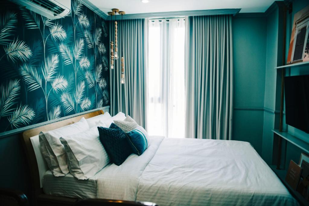 八打雁503 One Pontefino Towers的一间卧室配有一张蓝色墙壁的床和一扇窗户